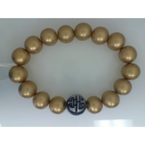 Stretch Bracelet with 12mm Gold Wooden Beads and  One 14mm Blue & White Porcelain Bead Barnes Jewelers Goldsboro, NC