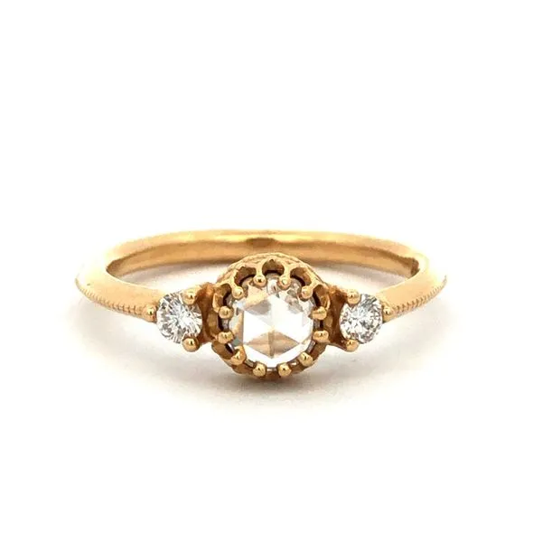 This three stone style ring is made of 14Kt yellow gold and features a 0.22ct rose cut round diamond center stone. The sides are accented with 0.16cttw round brilliant diamonds. The top half of the ring has a milgrain center design. Hudson Valley Goldsmith New Paltz, NY