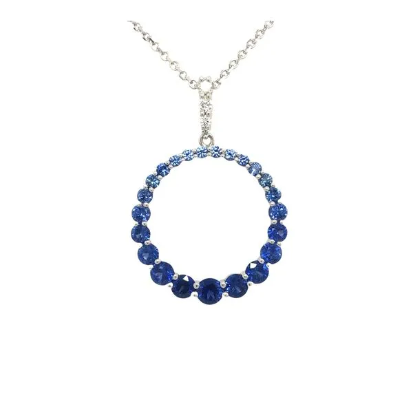 14k white gold circle pendant featuring 1.23ctw genuine blue sapphires tapering smaller to larger and also light to darker tones. Set along the front of the bail are 0.06cttw round brilliant diamonds. The pendant includes a 14k white gold chain 18