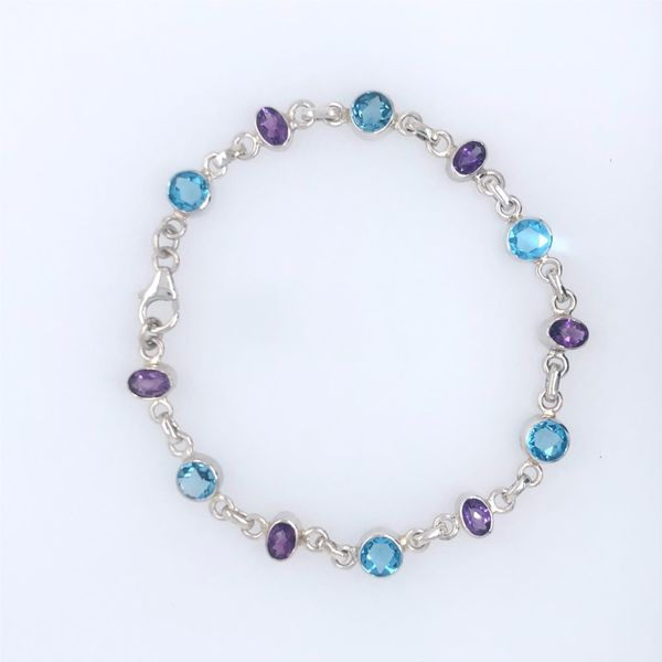Sterling silver bracelet with round blue topaz and oval purple amethyst. All the gemstones are bezel set in an alternating patte Hudson Valley Goldsmith New Paltz, NY