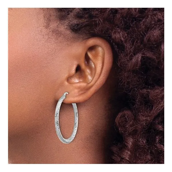 These 14k white gold diamond-cut round hoop earrings are a classic addition to any jewelry collection. The hoops are polished to a high shine and feature a diamond-cut design that adds a touch of sparkle. With a 3mm width, these earrings are lightweight a Image 2 Hudson Valley Goldsmith New Paltz, NY