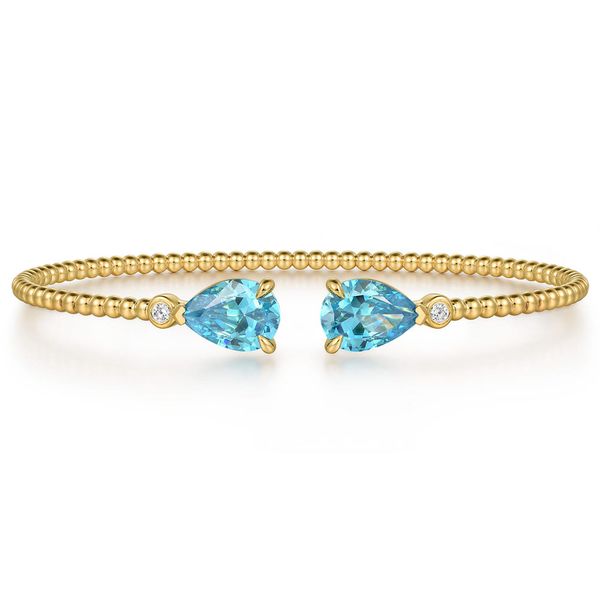 Gabriel & Co. 14K yellow gold Bujukan bangle with pear shape blue topaz on each end and diamond accents