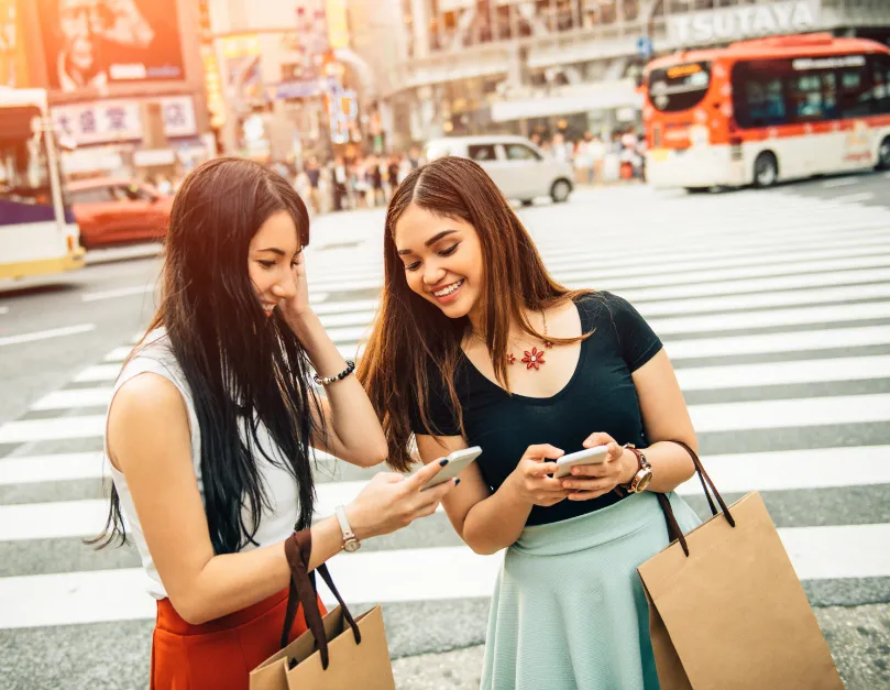 Two Models Looking at Phones at a Crosswalk