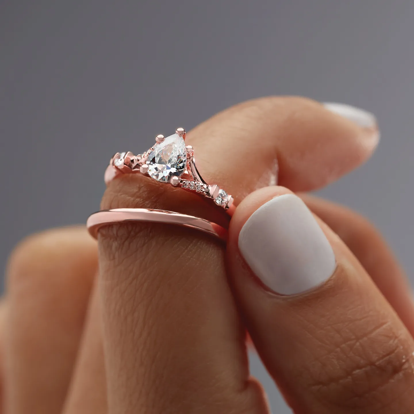 Four elegant wedding bands in gold, silver, and rose gold displayed on a textured surface. 