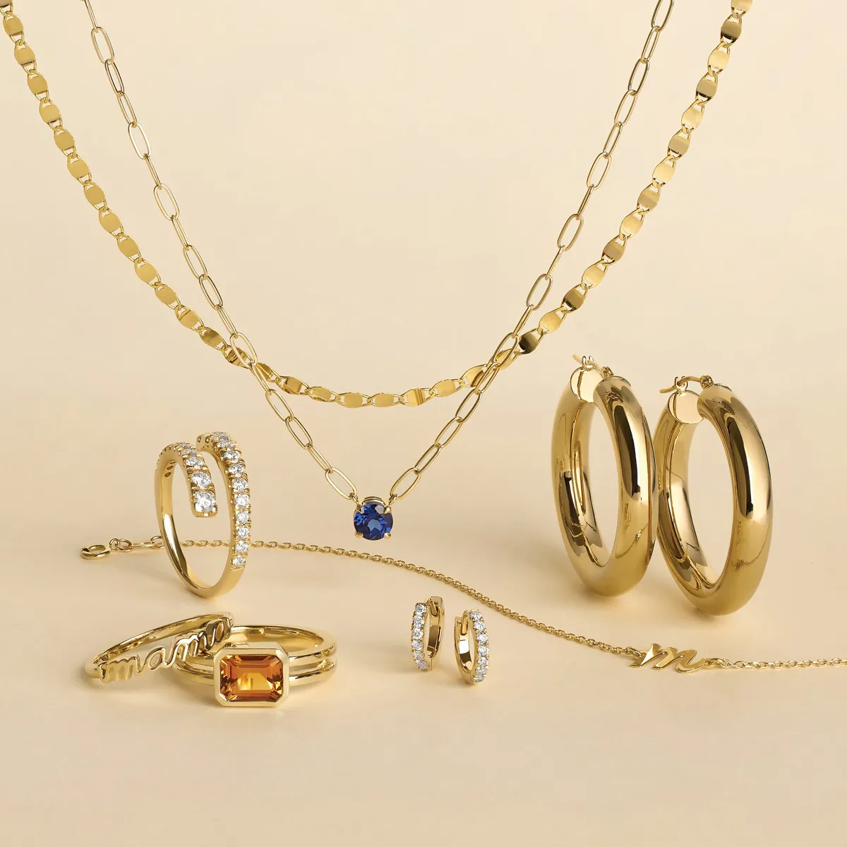 Gold jewelry collection featuring necklaces, rings, and earrings on a beige background.