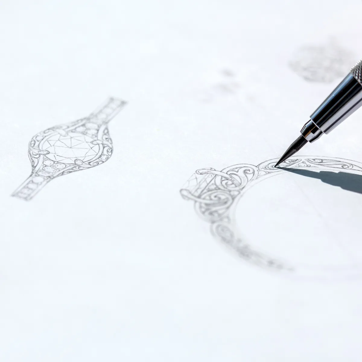 Close-up of a hand sketching intricate jewelry designs on paper for custom pieces.