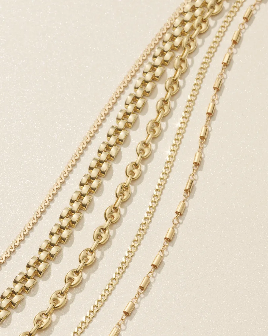 Various gold chains displayed on a light background, showcasing different styles and designs.