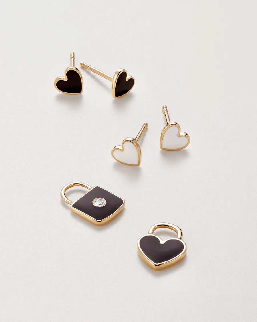 Gold heart-shaped earrings and charms, including a padlock design, displayed on a light background.