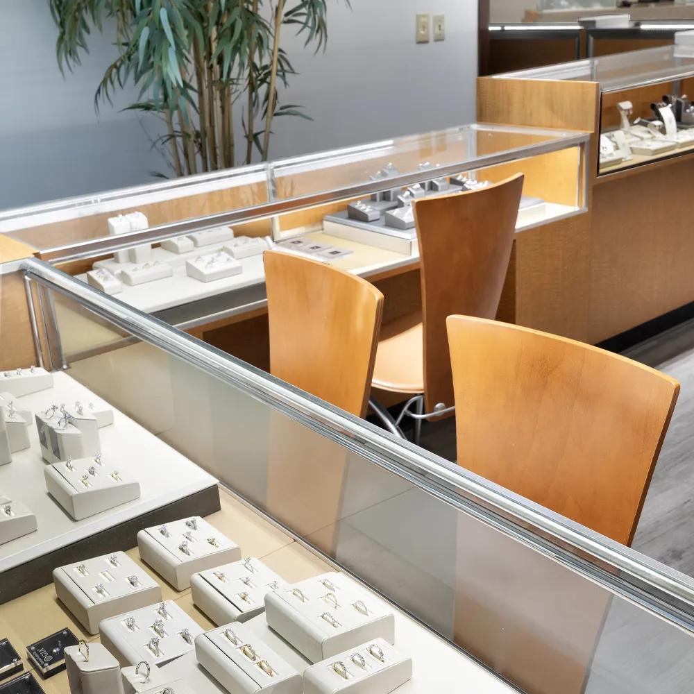 Jewelry display cases with rings and earrings in a modern jewelry store, Ambassador Diamond Jewelers in Tucson.