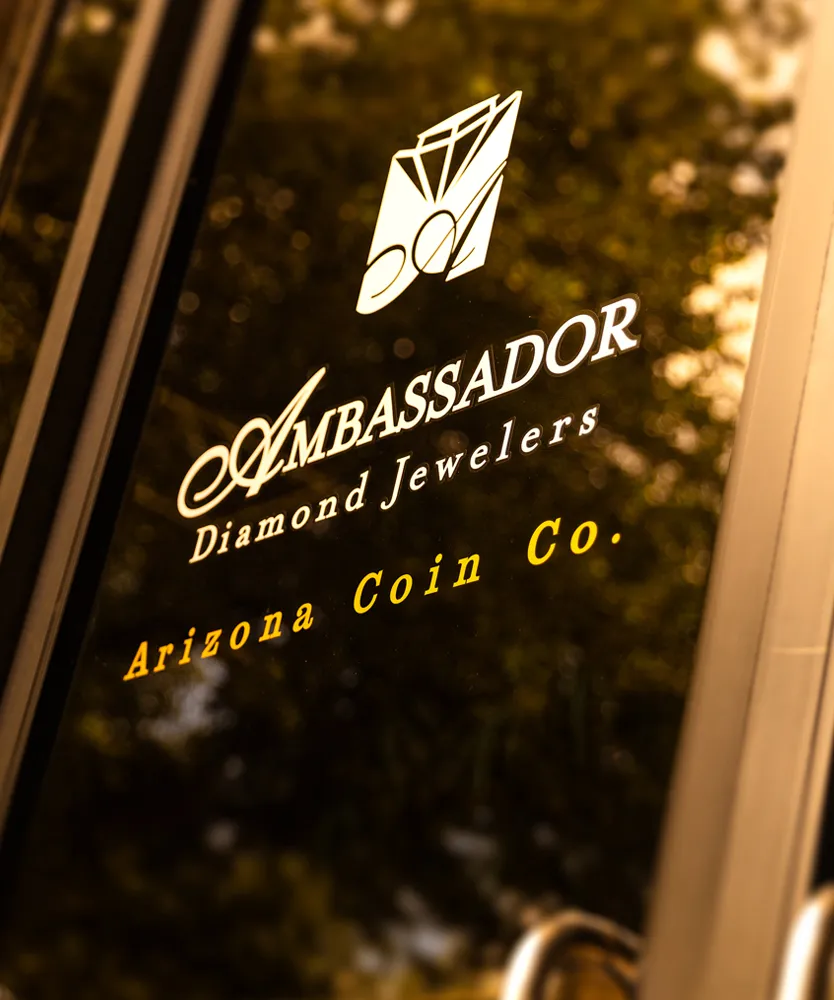 Ambassador Diamond Jewelers storefront sign in Tucson, featuring elegant branding and logo.