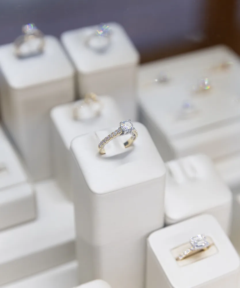 Elegant engagement ring with a large diamond, displayed among other fine jewelry at Ambassador Diamond Jewelers in Tucson.