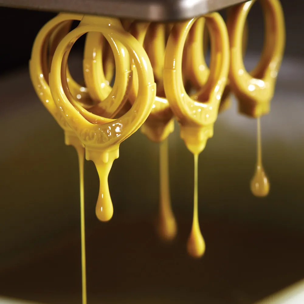 Golden wax ring molds with wax dripping from the mold