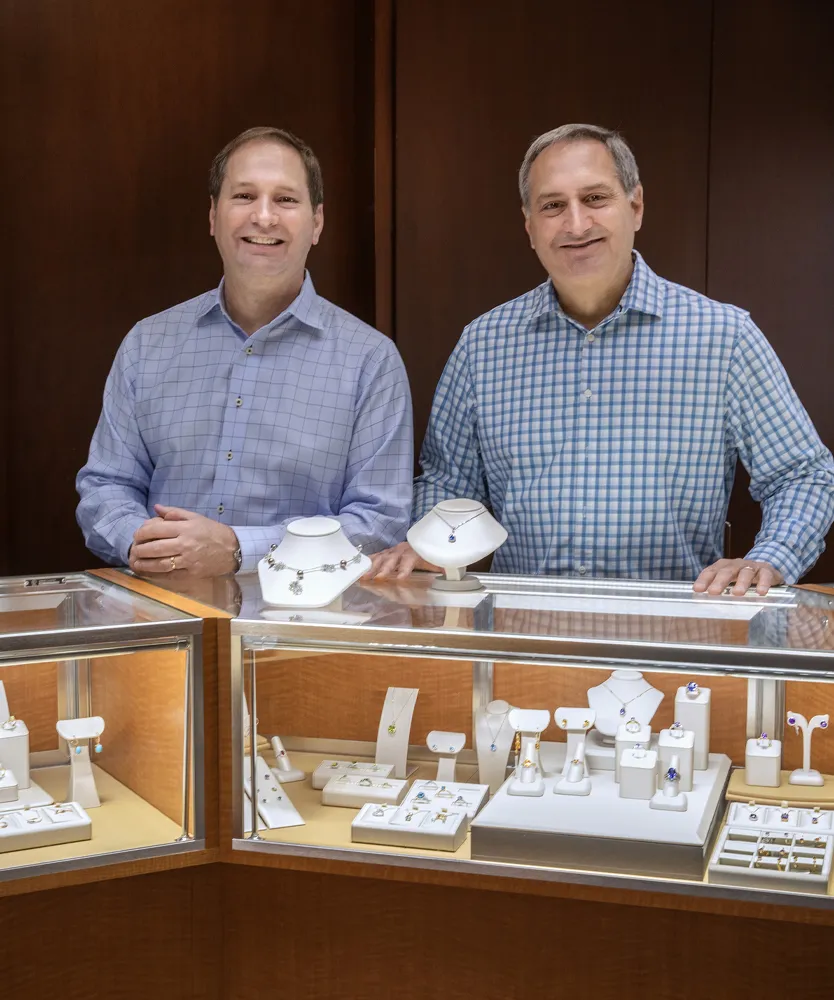 Mike and Jim standing in front of a jewelry display case at Ambassador Diamond Jewelers.
