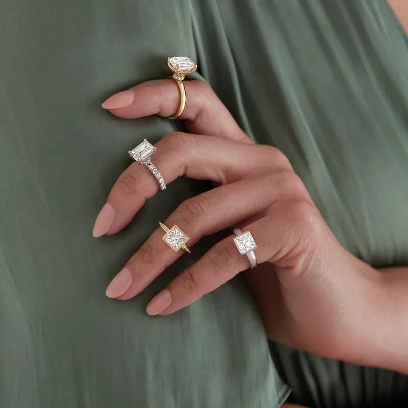Five elegant engagement rings displayed on a hand, showcasing various styles and settings.