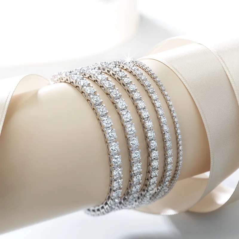 Three elegant diamond bracelets displayed on a soft surface, showcasing their sparkle and design.
