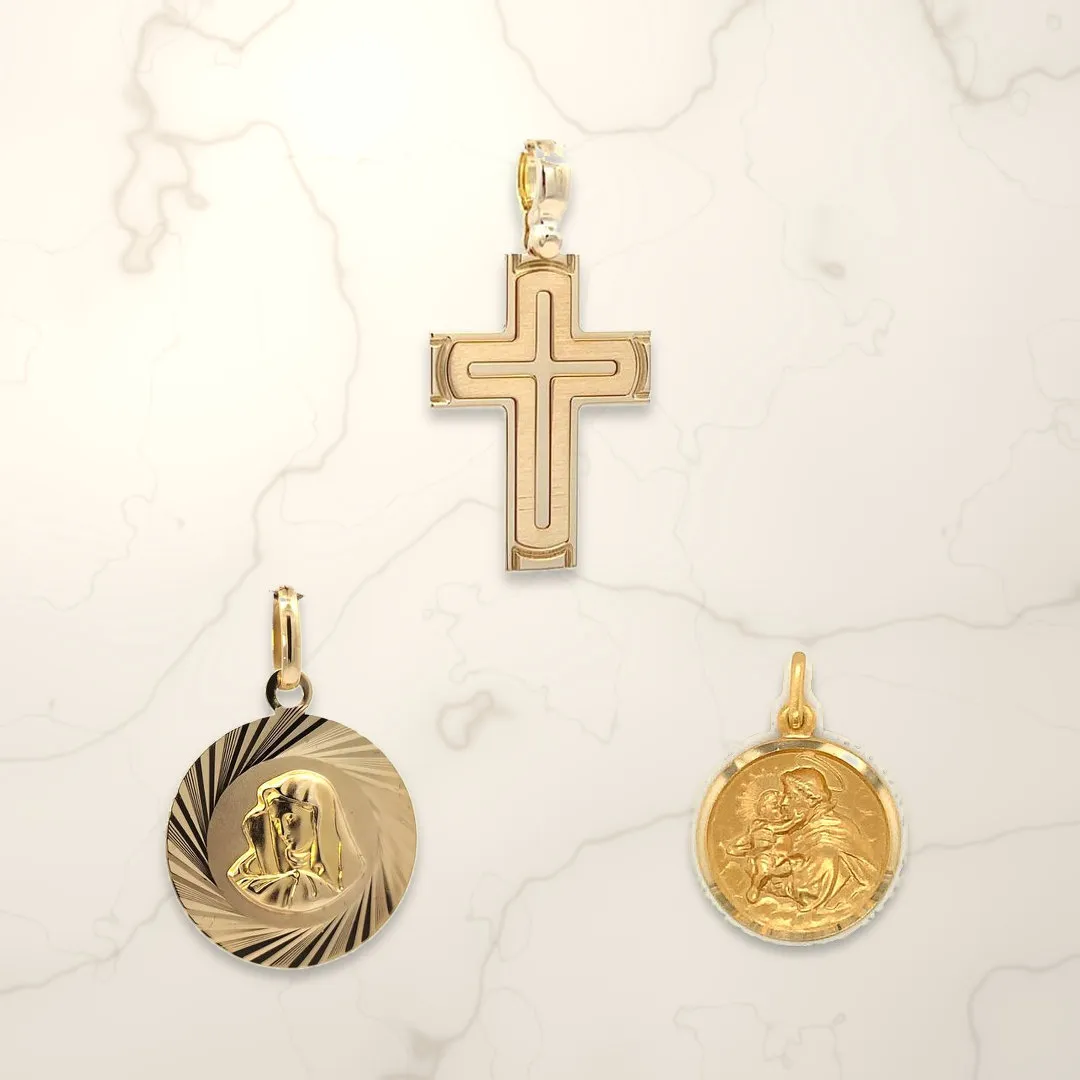 18K yellow gold cross pendant, Virgin Mary medal and St. Anthony medal, made in Italy, on cream marble