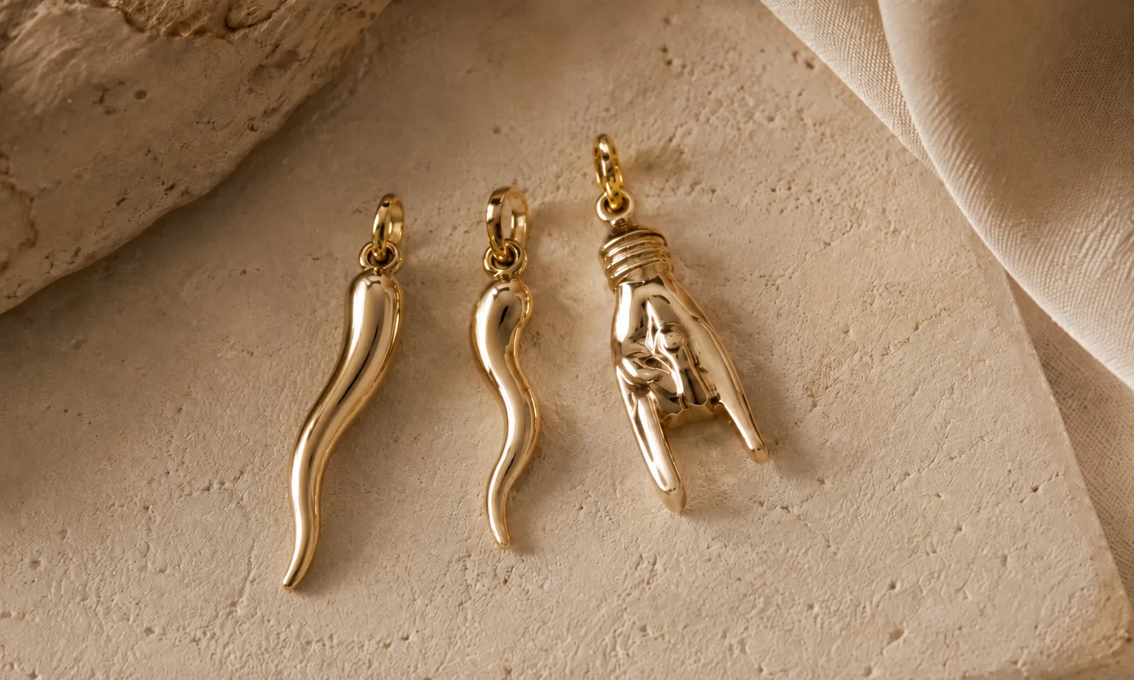 Traditional red Italian cornicello beside a gold Italian horn pendant