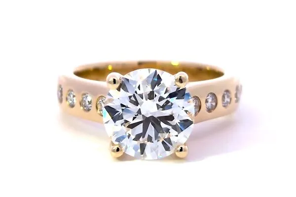 Lab-grown diamond engagement ring in 14k yellow gold with a round center stone and accent diamonds. Click to view details.