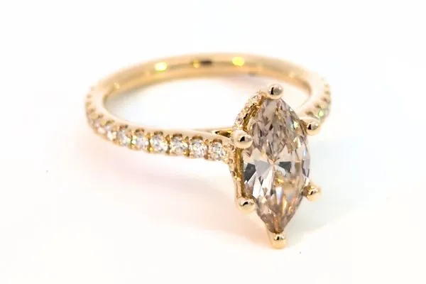 Elegant gold engagement ring with an emerald-cut center stone and diamond accents, inspired by Taylor Swift. Click to view.