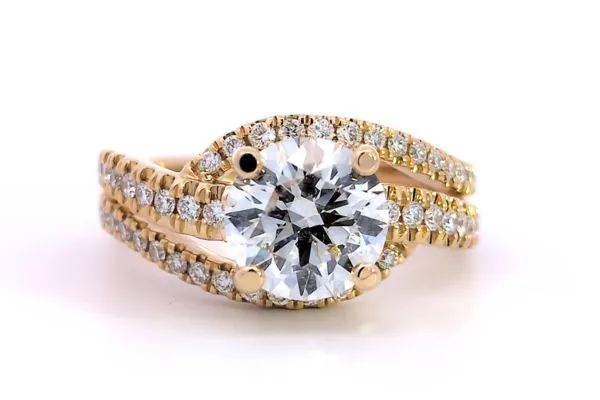 Elegant gold engagement ring with a large round diamond and smaller diamonds on the band. Click to view more at Arezzo Jewelers.
