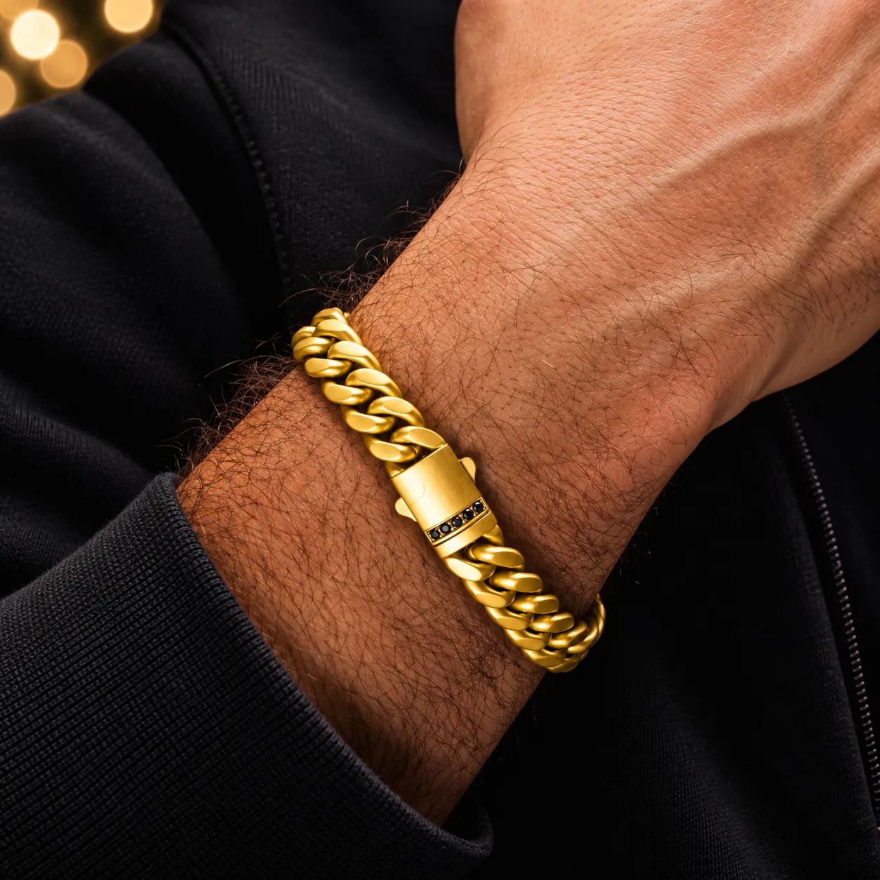 Gold-tone men's curb-link bracelet with black stone clasp detail