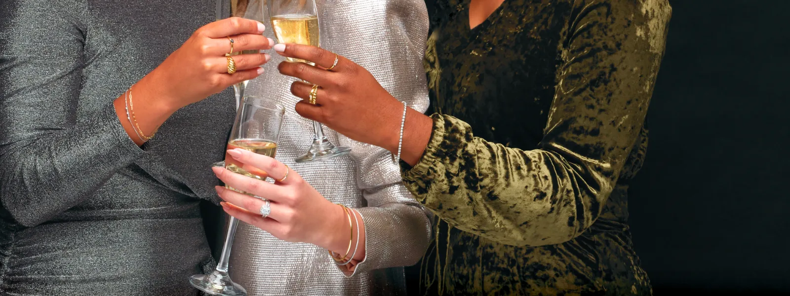 Women with diamond jewelry holding glasses of champagne