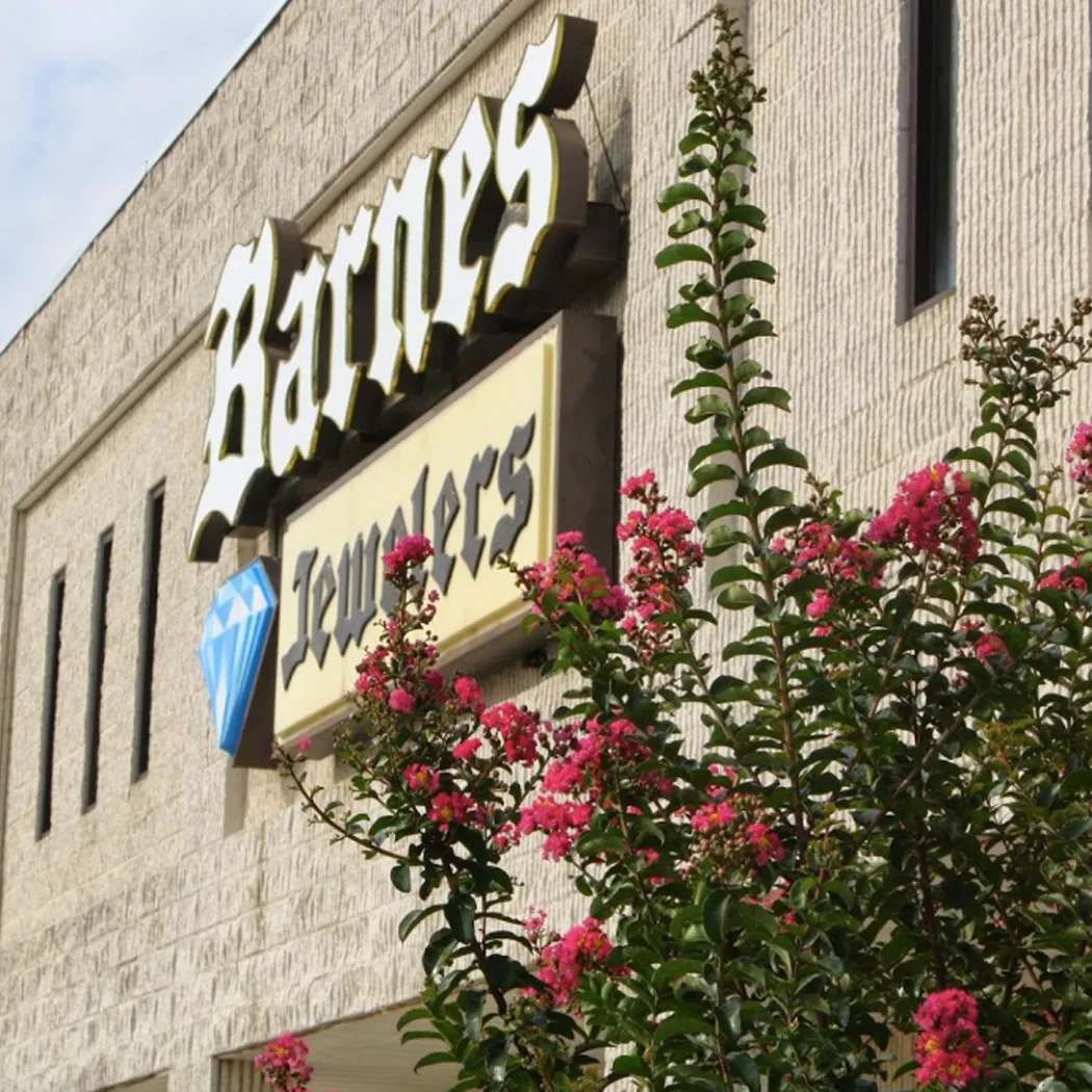 Barnes Jewelers sign with pink flowers in front, located in Goldsboro, NC.