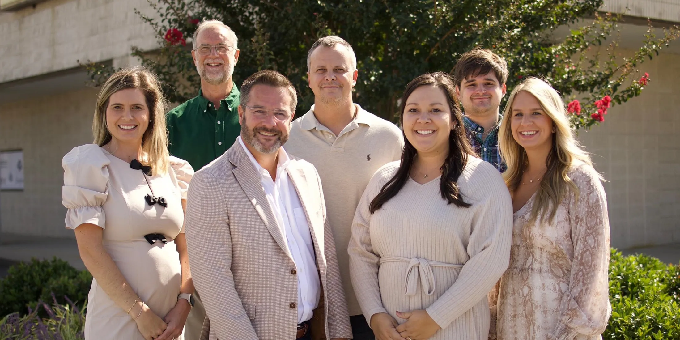 A group photo of the Barnes Jewelers team, smiling outdoors, promoting personalized jewelry consultations.