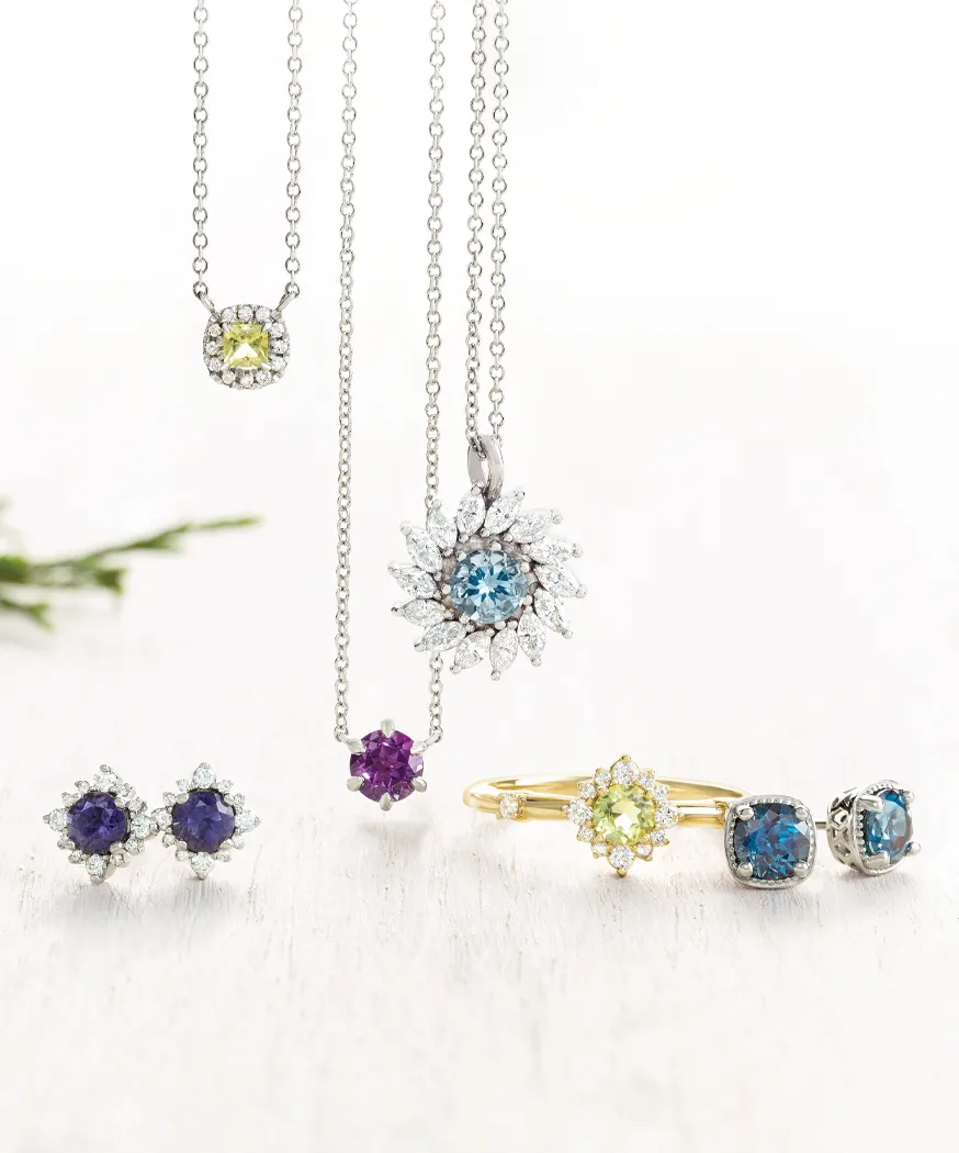 Elegant jewelry display featuring colorful gemstone earrings, necklaces, and a ring.