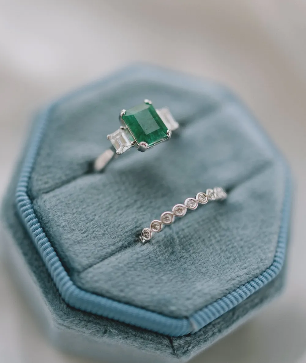 Emerald and diamond rings displayed on a blue velvet ring box at Barnes Jewelers in Goldsboro.