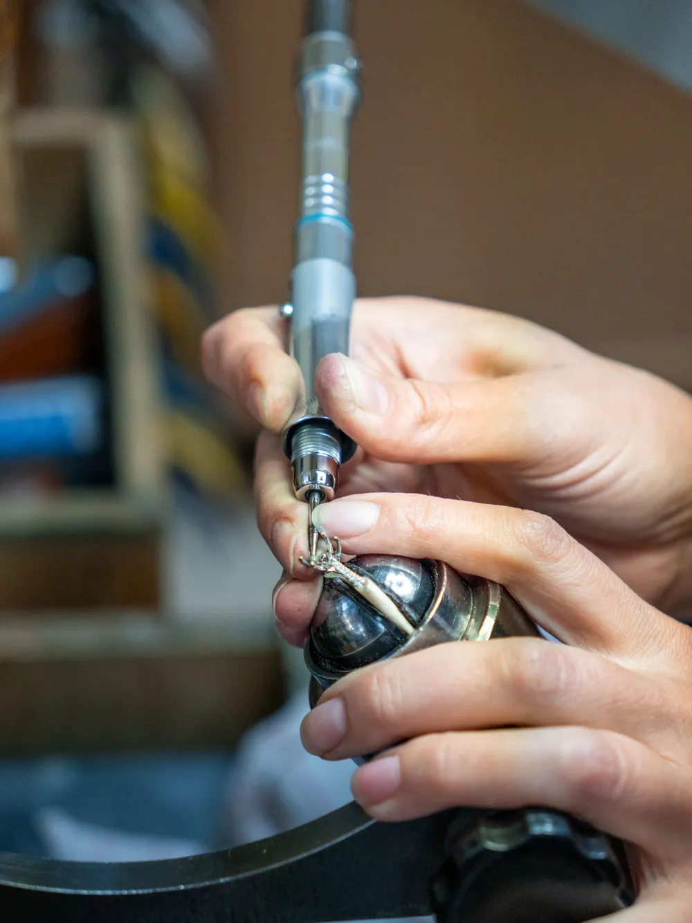 A Bay Area Diamond jeweler at the bench, working on a ring with a polishing tool