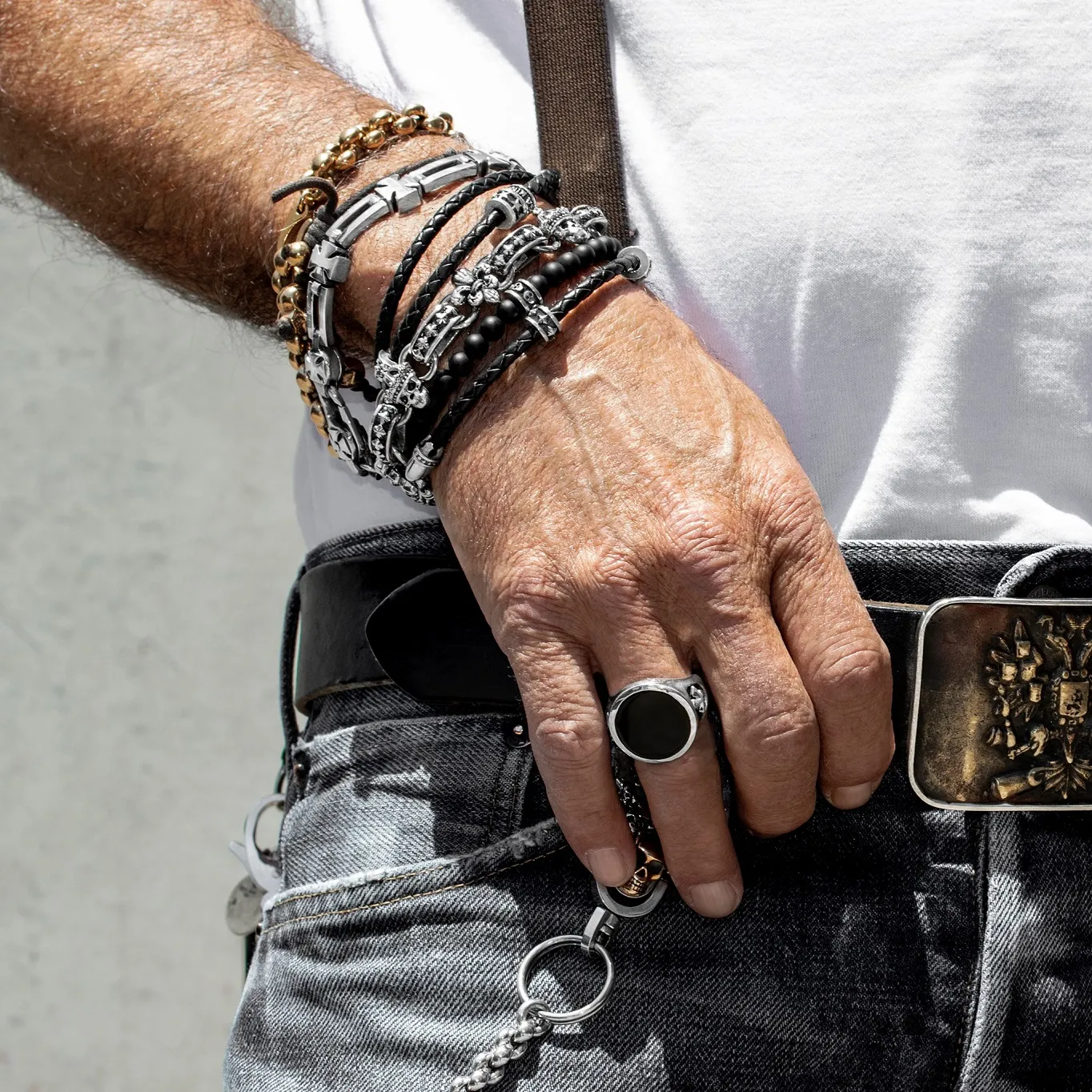 photo of a man's wrist wearing a few durable bracelets while wearing a couple of cool rings. All of these pieces give off a rock 'n roll vibe and they're from our King Baby line