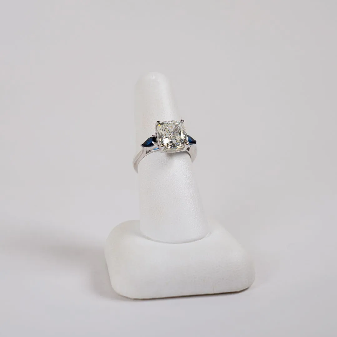  18 Karat White Gold 3 Stone Fashion Ring with a 5.03 Carat Cushion Modified Brilliant Shaped Center Diamond and 2 Blue Sapphire Accent Stones Bay Area Diamond Company Green Bay, WI