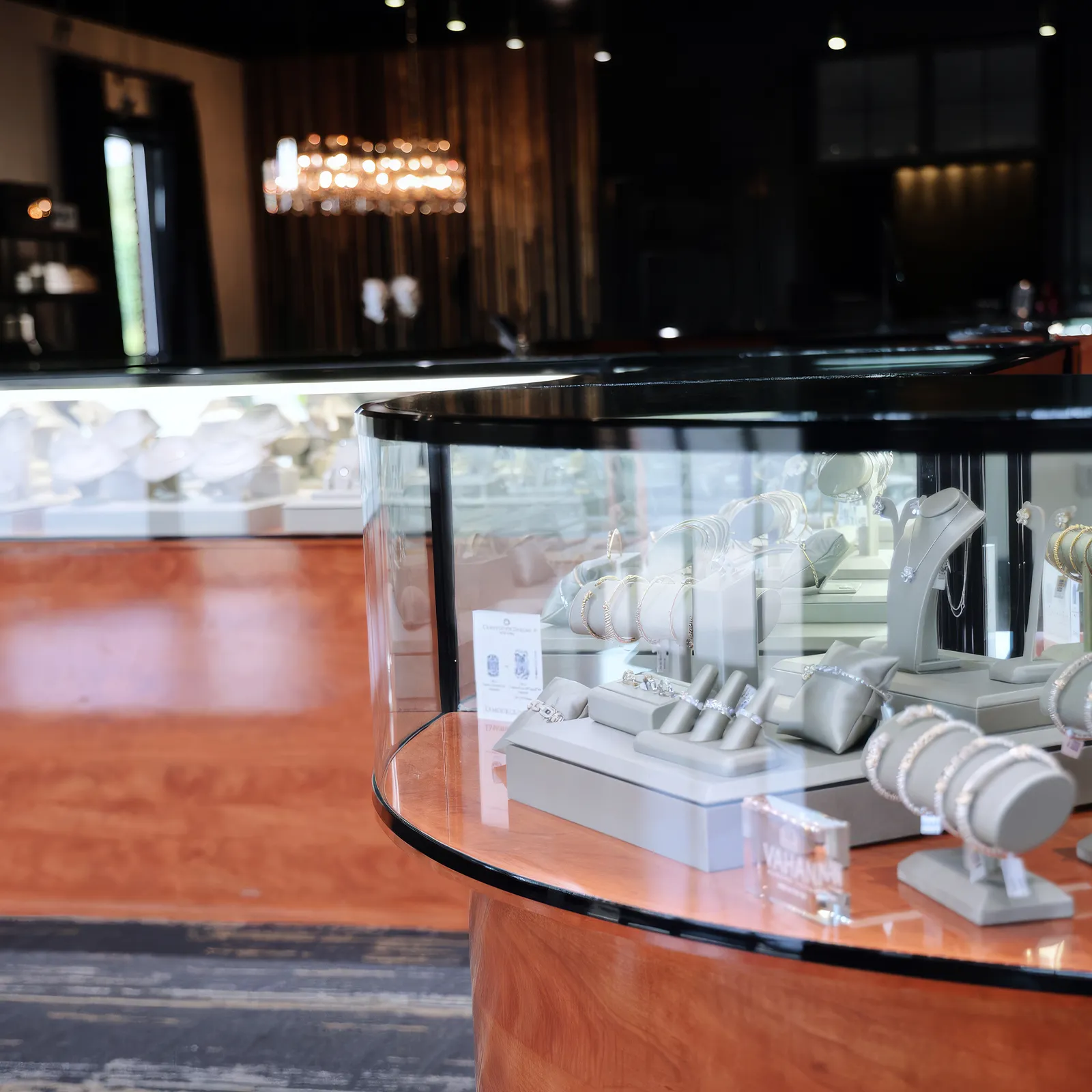 Jewelry display case with bracelets and necklaces in a store setting.