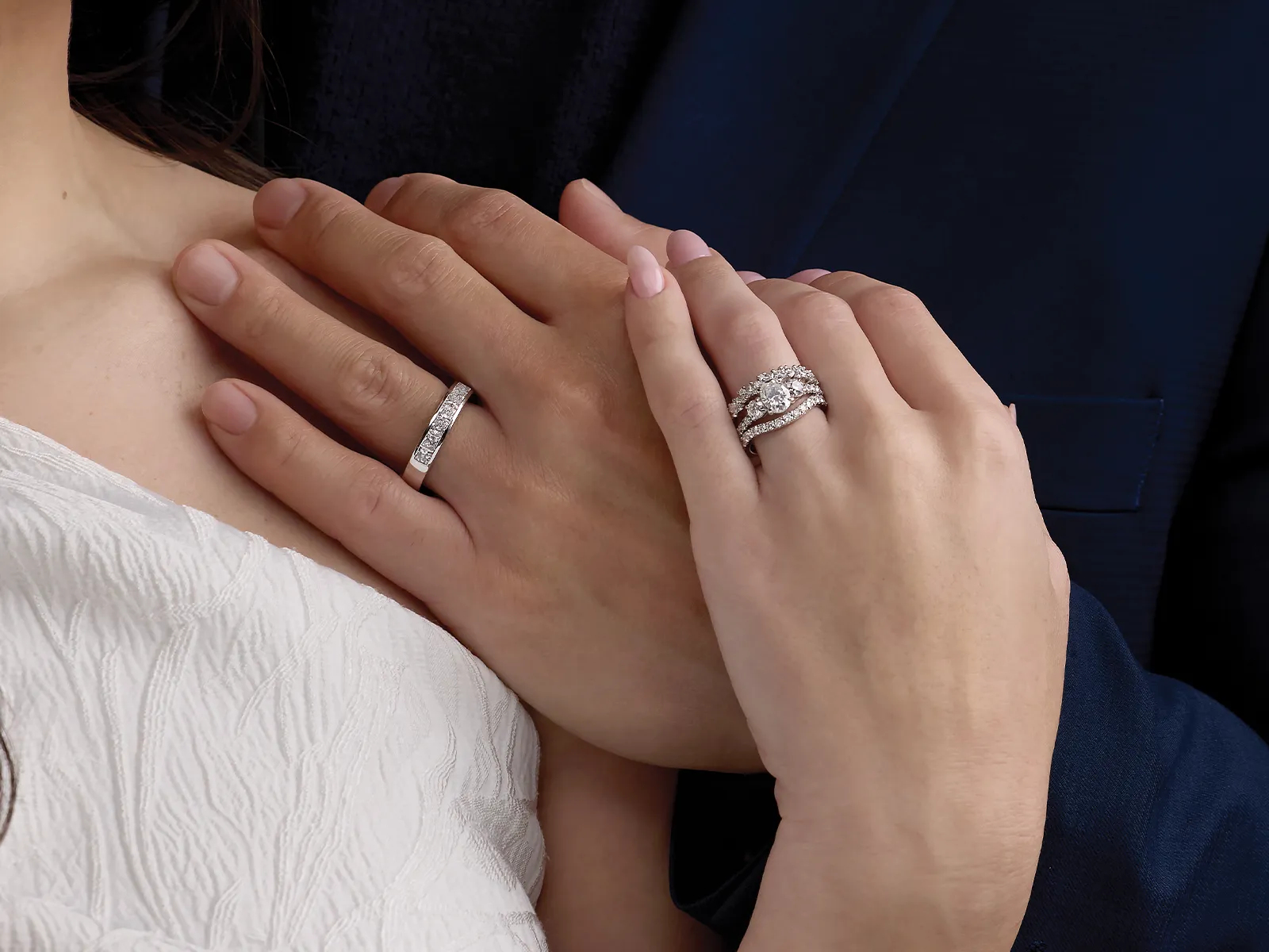 Couple's hands with diamond wedding bands, close-up.