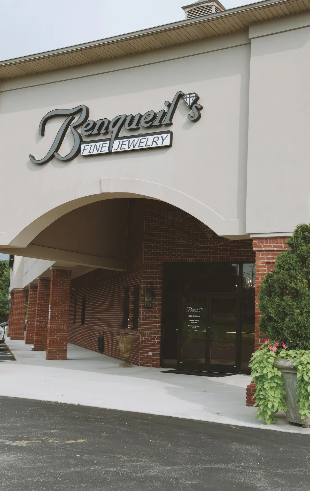 Exterior of Benqueil's Fine Jewelry store with brick facade and large sign.