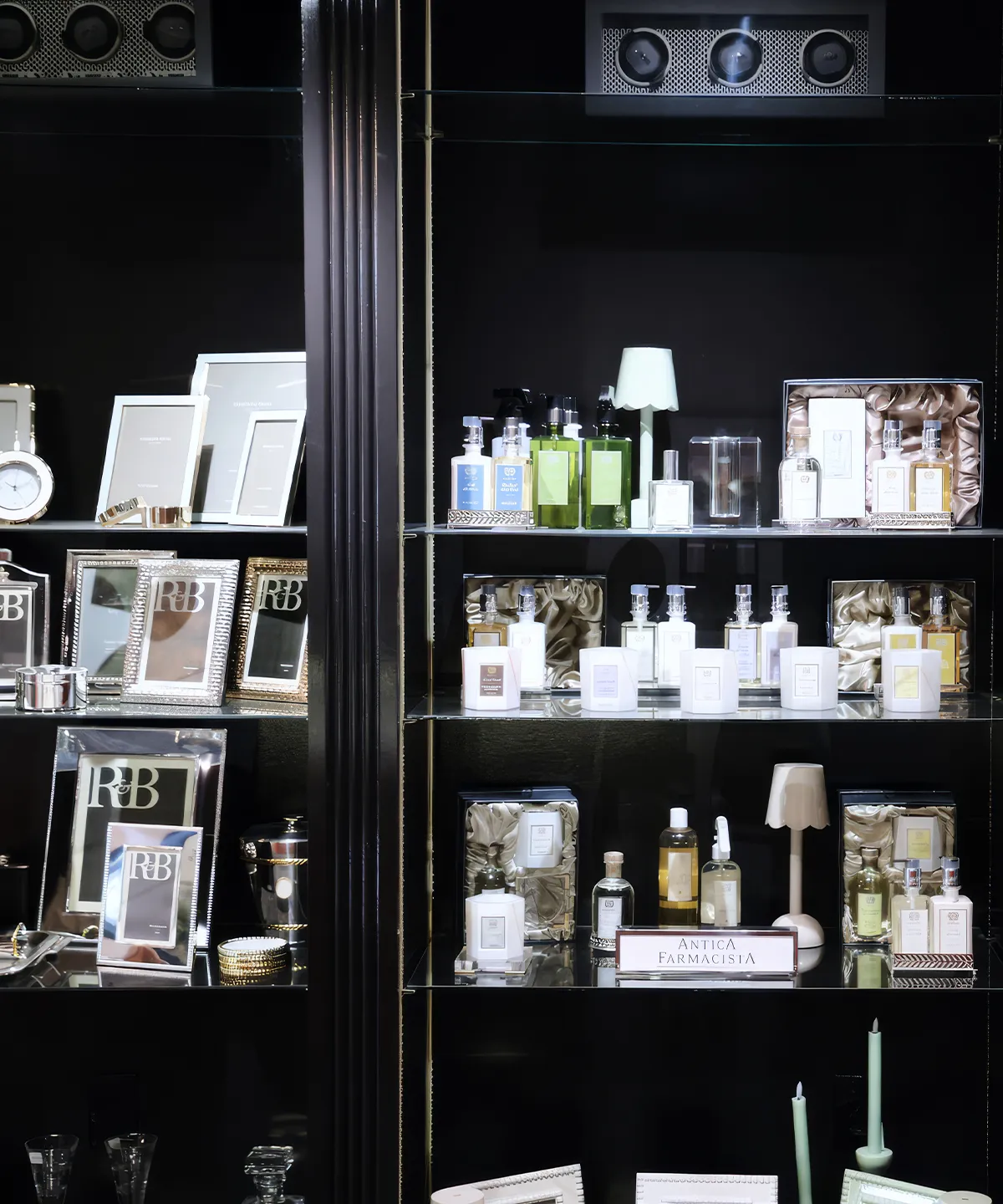 Shelves displaying framed photos, perfumes, and home decor items in a store.