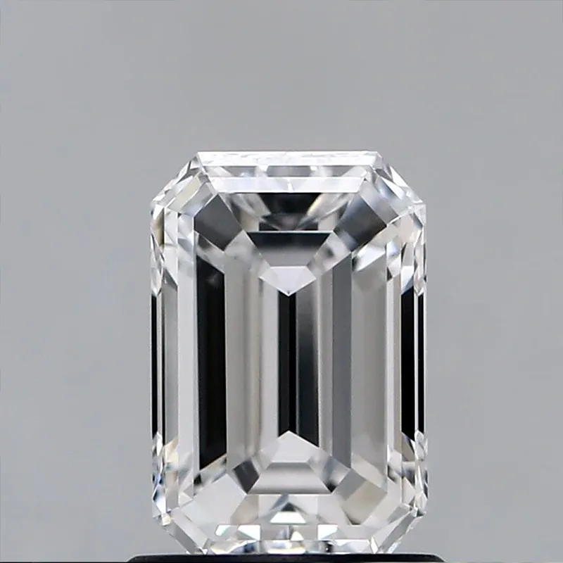 A large loose emerald cut Teva color enhanced diamond resting on a pale surface