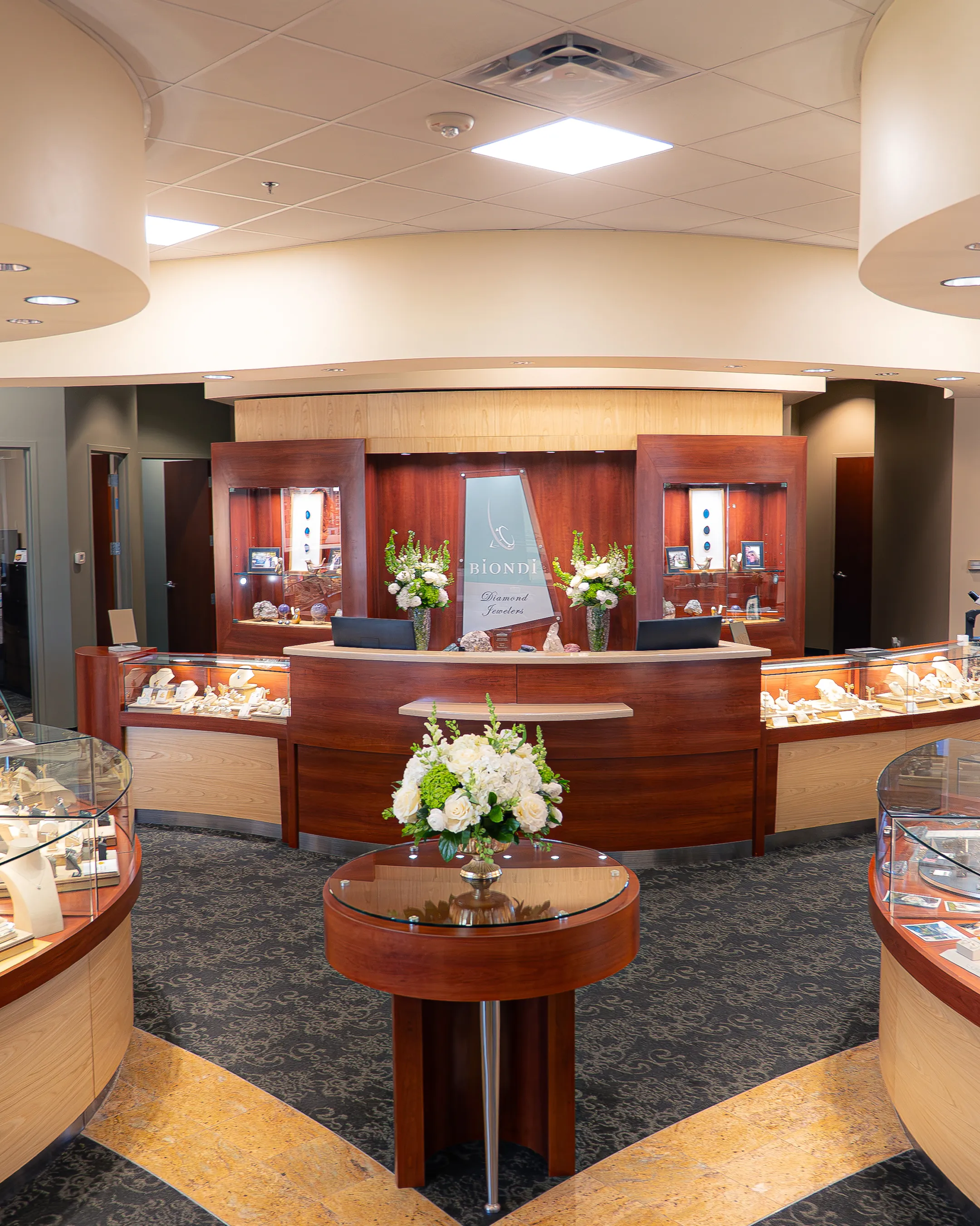 Jewelry store showroom with glass display cases showcasing necklaces and bracelets.