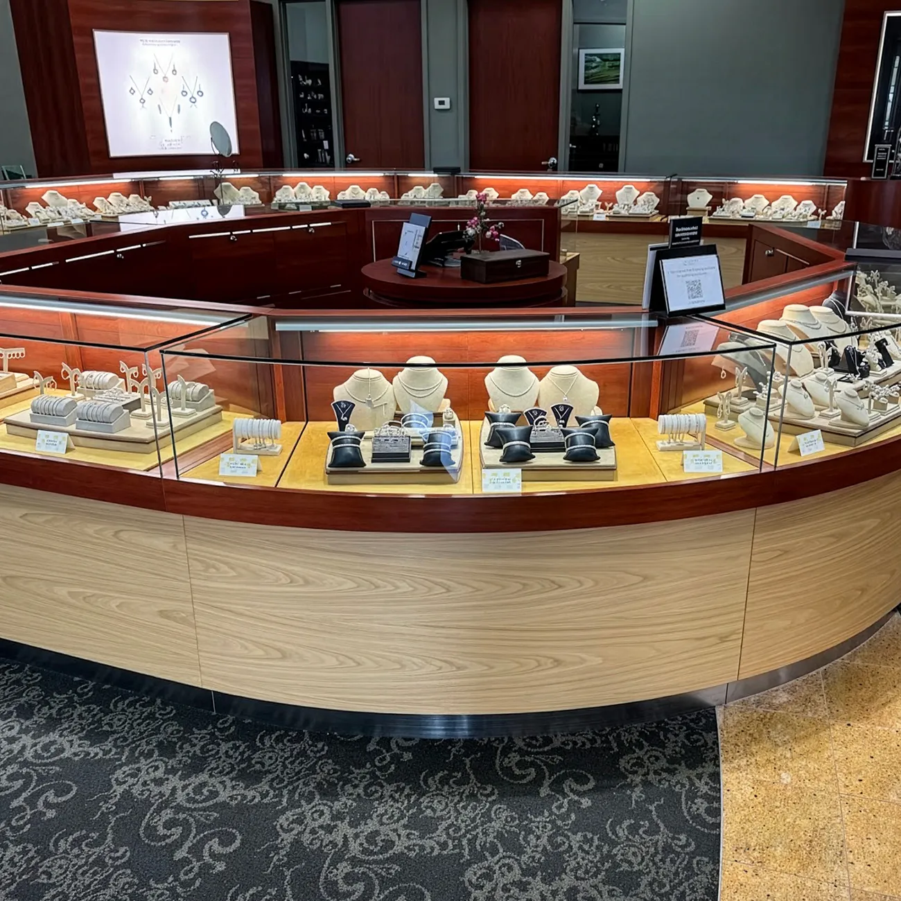 Jewelry store showroom with glass display cases showcasing necklaces and bracelets.