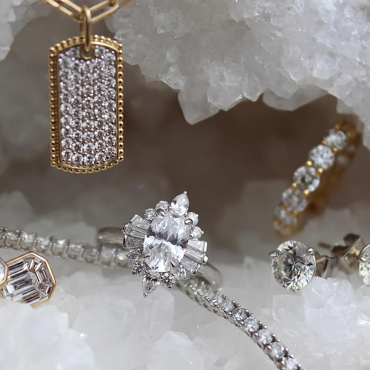 Elegant diamond jewelry including rings, earrings, and a pendant displayed on crystals.