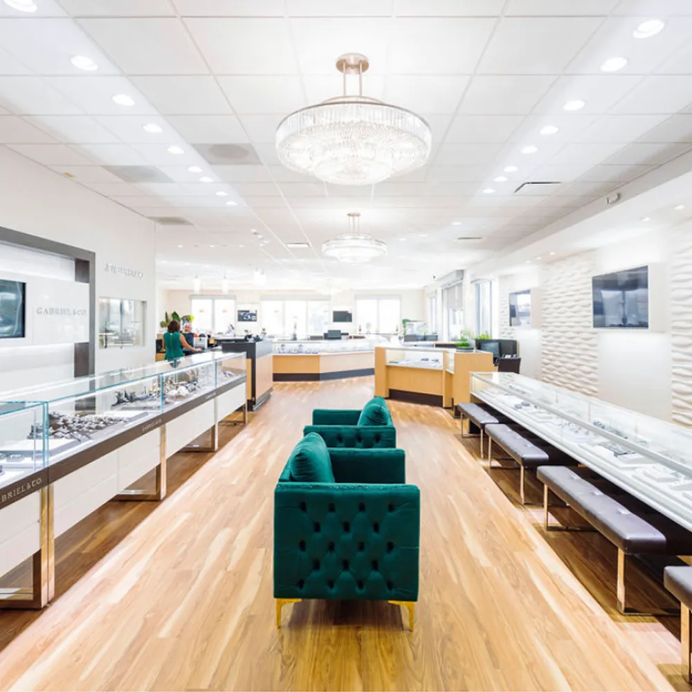 Bright, elegant jewelry store interior with display cases, green seating, and chandeliers at Bradley's Jewelers, Jacksonville.