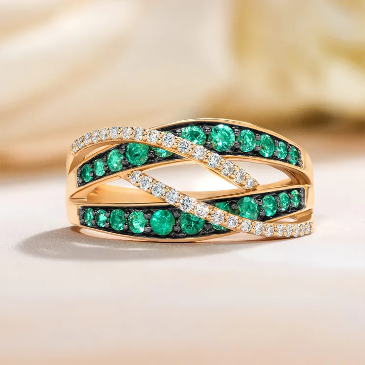 Elegant gold ring with green and white gemstones in a crisscross design.