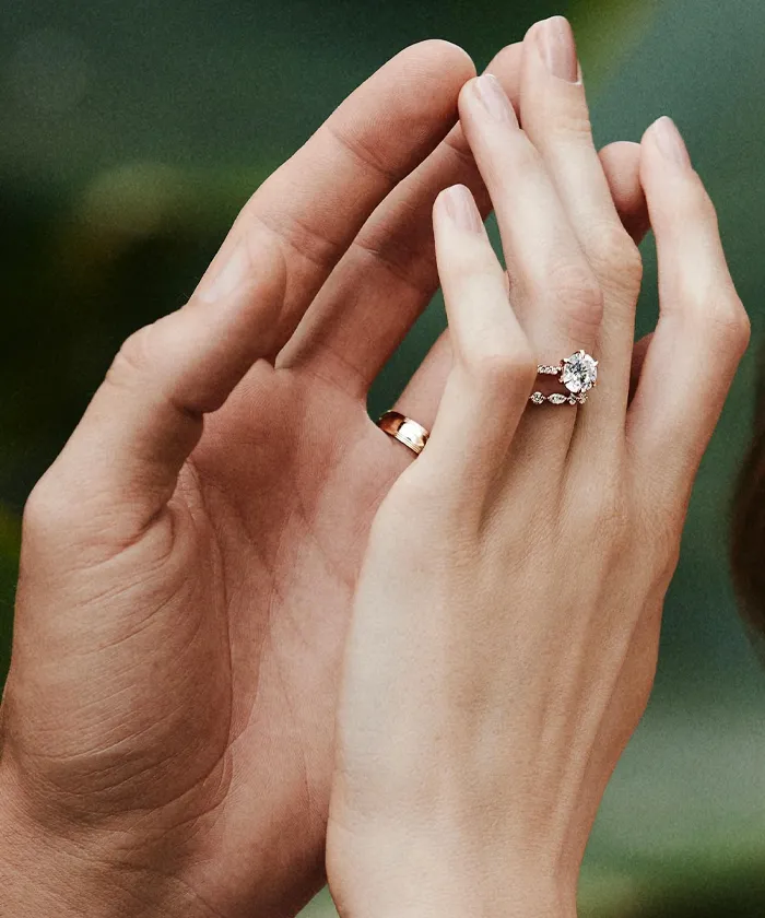 Hands with wedding rings and an engagement ring, symbolizing love and commitment.