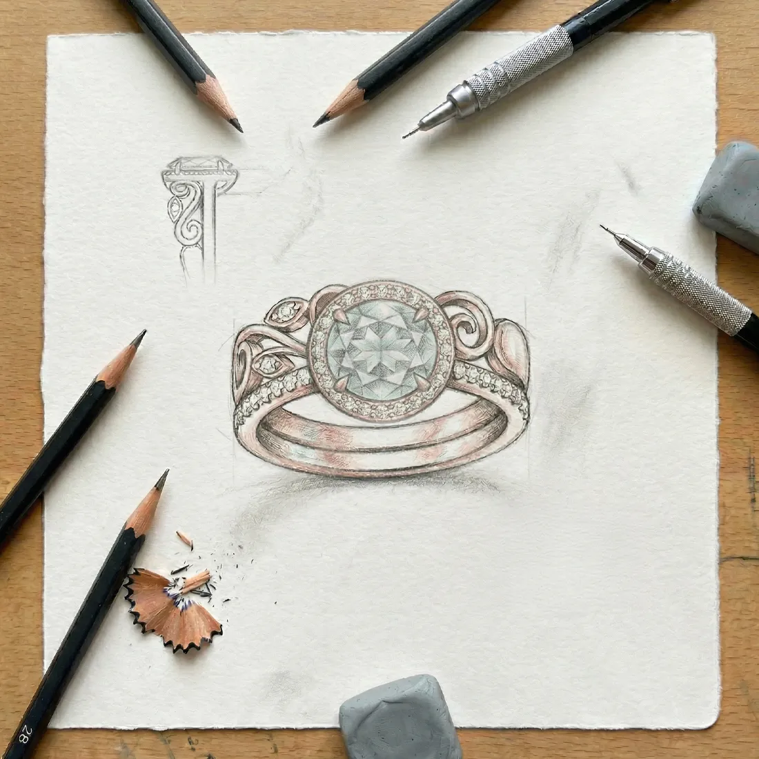 Jewelry design sketch with pencils and erasers on a wooden table.
