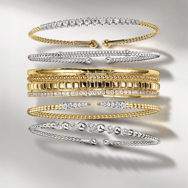 Stacked gold and silver diamond bracelets on display.