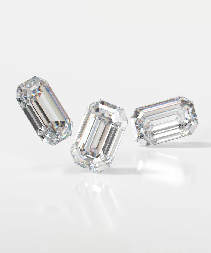Three emerald-cut diamonds on a white background, showcasing clarity and brilliance.