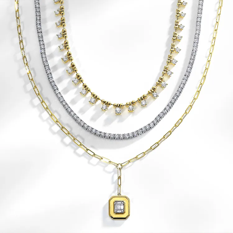 Three layered necklaces: diamond, gold with diamonds, and gold with a pendant.