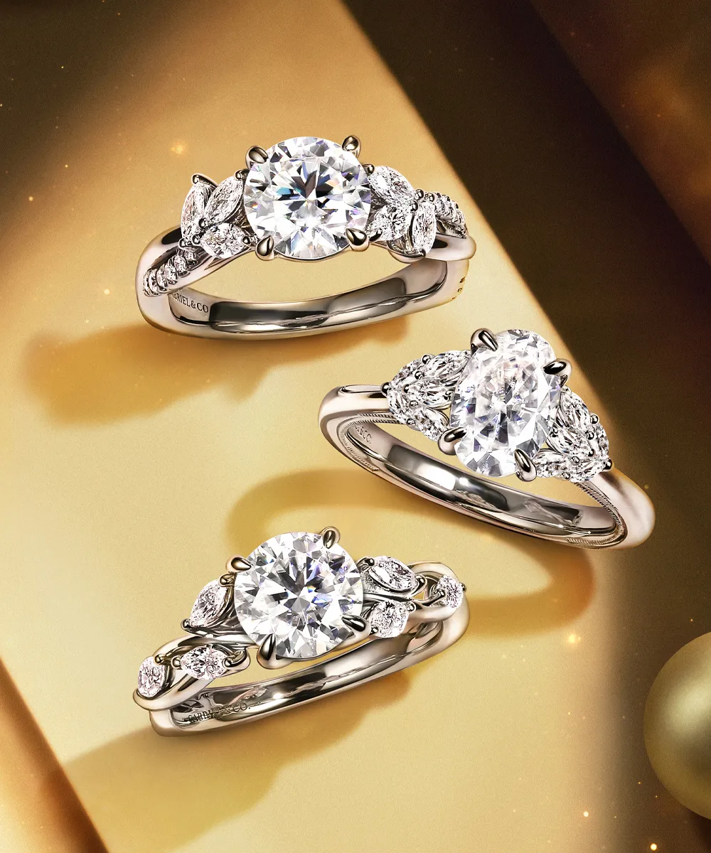 Three elegant diamond engagement rings with intricate settings on a golden background.