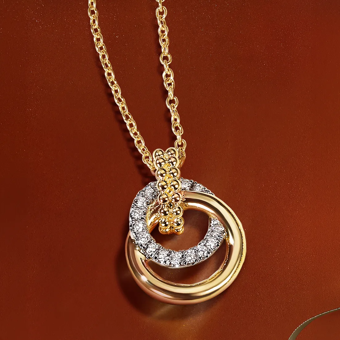 Gold and diamond interlocking circle pendant necklace on a chain.